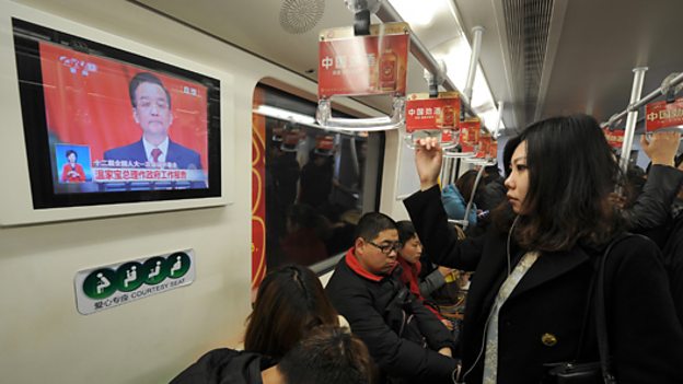 Commuters watch TV in Shanghai